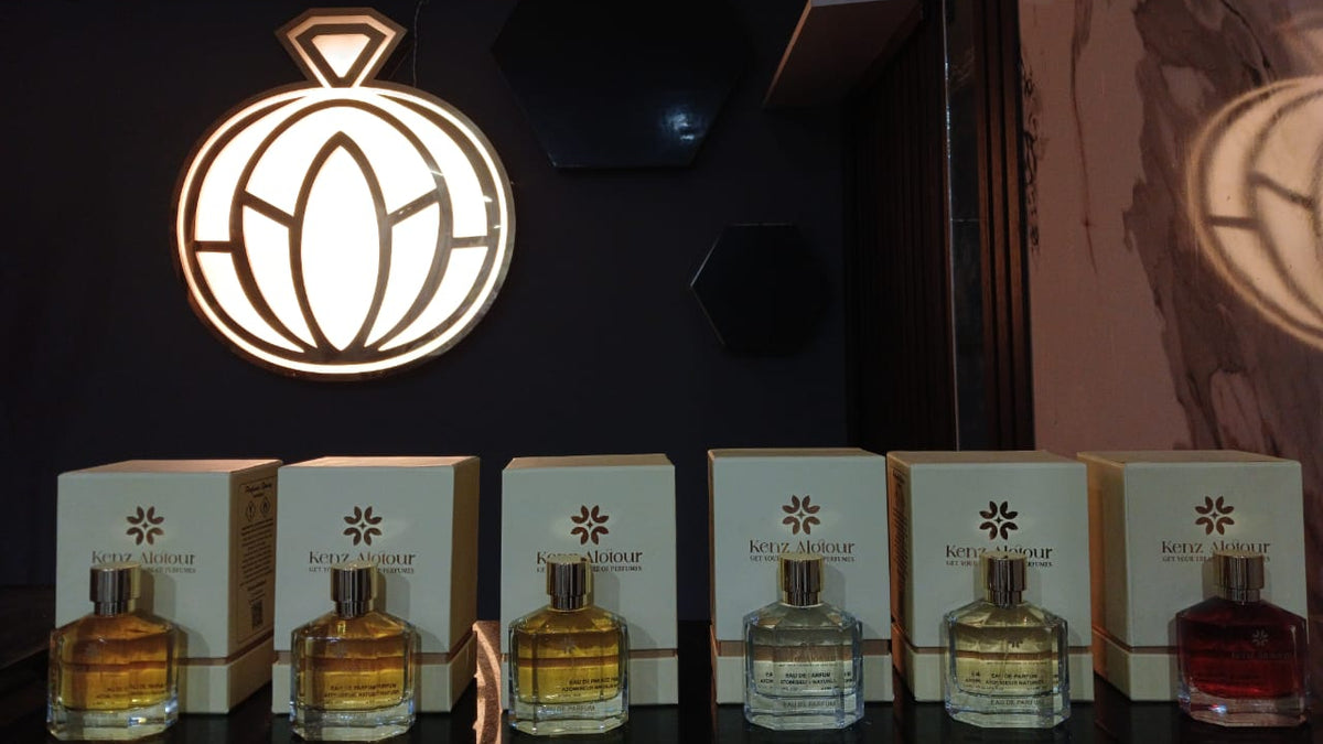 Perfume bottles and boxes with a brand logo in the background
